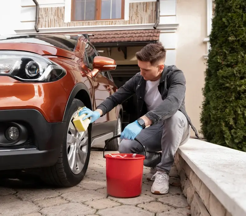 Lavage auto à domicile Divonne-les-Bains : professionnel intervenant sur un véhicule